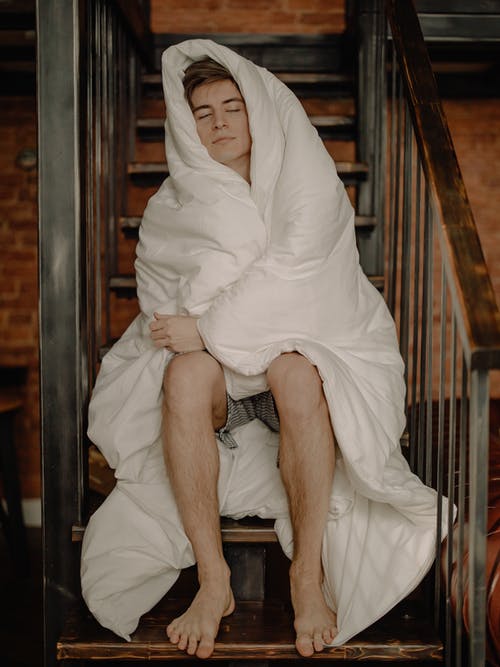 白头巾的女人坐在棕色的木椅上 · 免费素材图片