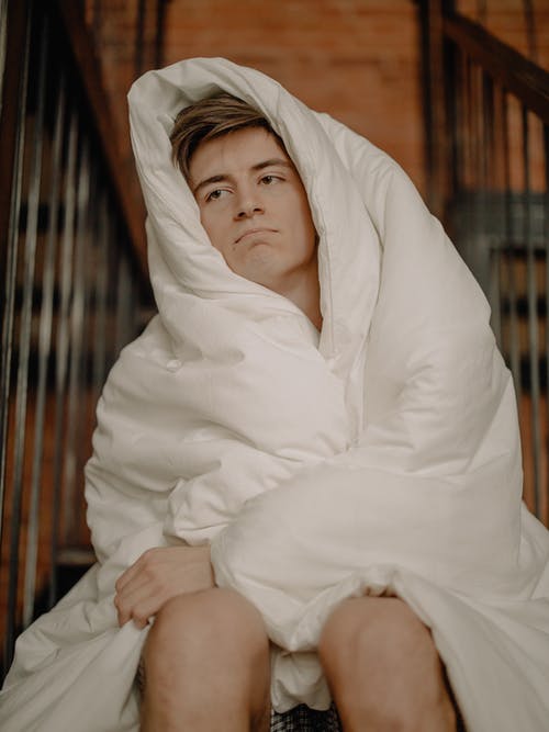 白头巾的女人坐在棕色的木椅上 · 免费素材图片