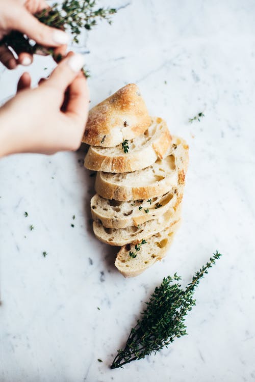 拿着白奶油黑面包的人 · 免费素材图片