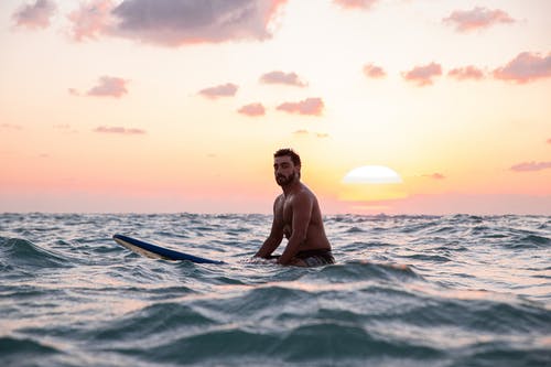 男子骑冲浪板的照片 · 免费素材图片