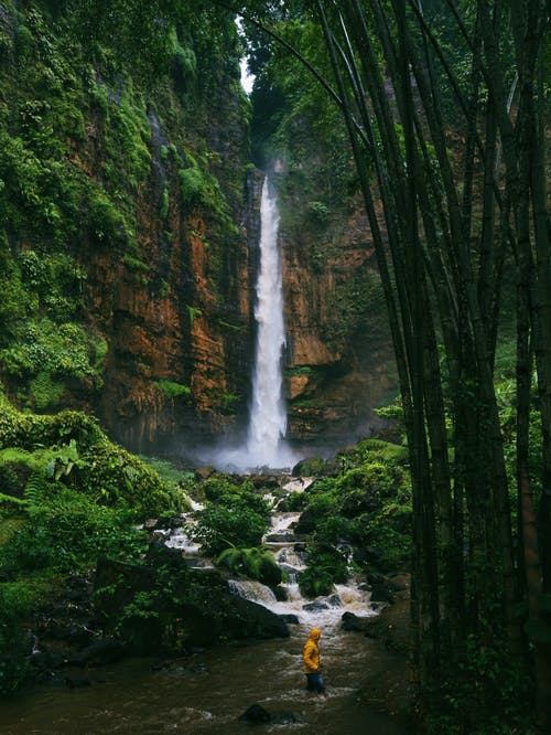 在河附近的绿色山脉的快速瀑布 · 免费素材图片
