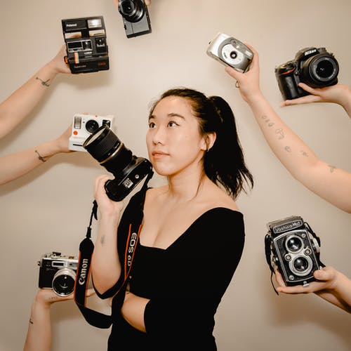 亚洲女人用手中的相机拍照 · 免费素材图片