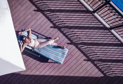 度假期间，无法识别的游客在酒店露台上的躺椅上休息 · 免费素材图片
