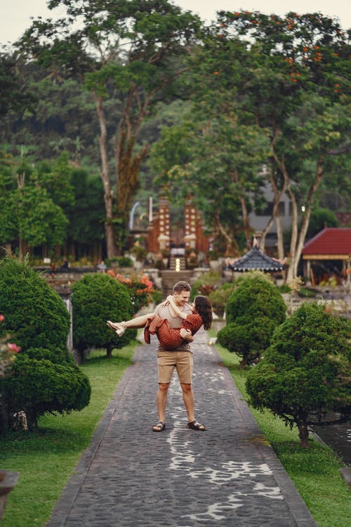 在热带花园中散步的年轻夫妇 · 免费素材图片