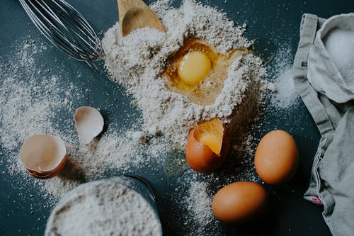 面包烘烤前撒在桌上的面粉和鸡蛋 · 免费素材图片