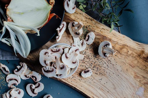 未煮过的蘑菇和洋葱放在桌子上用新鲜的迷迭香 · 免费素材图片