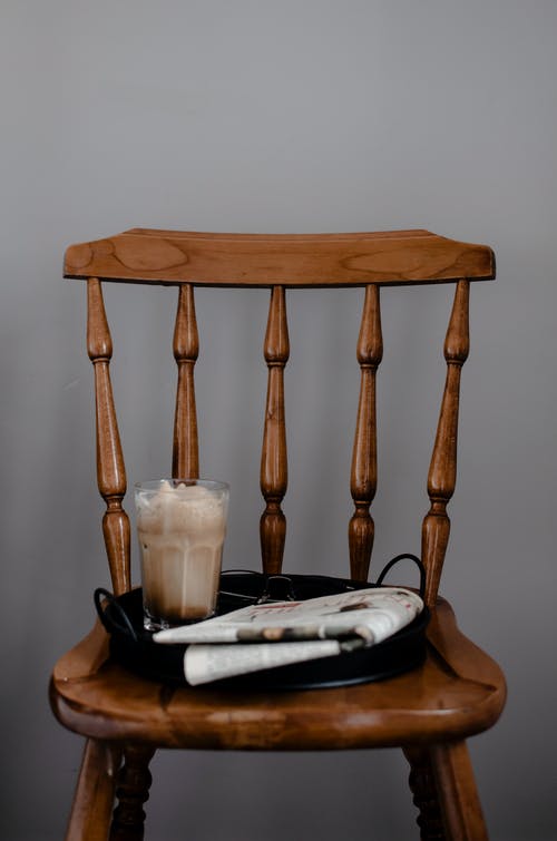 报纸和咖啡放在木椅上灰色背景 · 免费素材图片