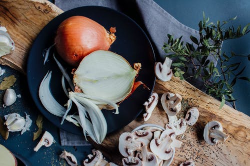 切碎的蘑菇和洋葱对分的桌子上用草药和香料 · 免费素材图片