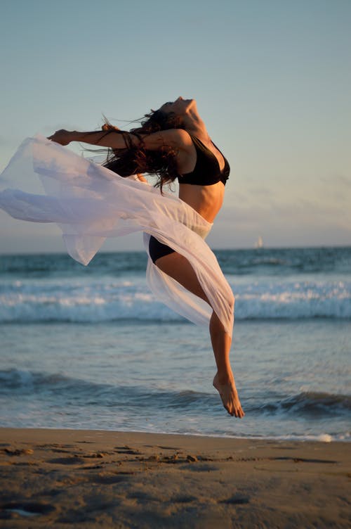 瘦舞者跳过海洋沙质海岸 · 免费素材图片