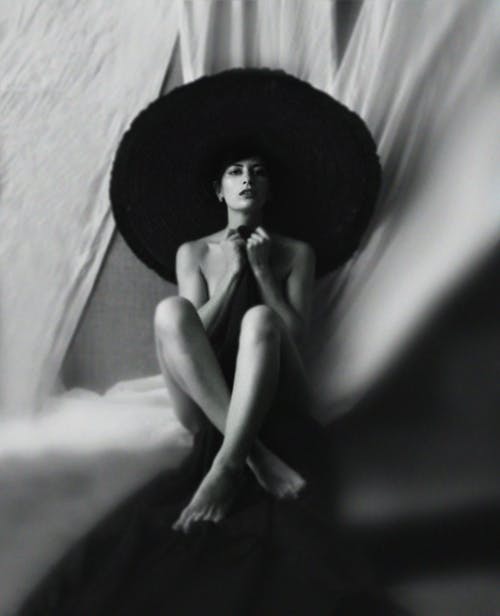 帽子坐和用毯子遮住身体的诱人的小姐 · 免费素材图片
