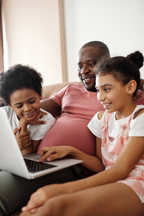 幸福的家庭，坐，看着一台笔记本电脑 · 免费素材图片