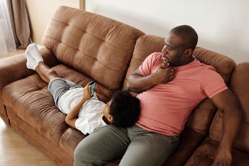 父亲和儿子在沙发上放松 · 免费素材图片