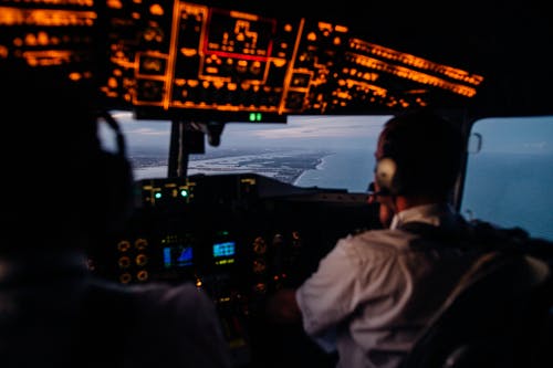 在海上飞行的飞机驾驶舱内的匿名飞行员 · 免费素材图片