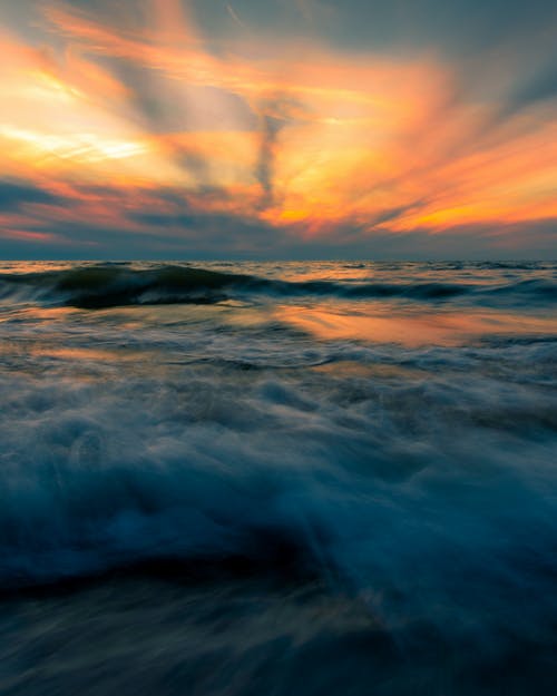 在波涛汹涌的海面多云明亮的夕阳的天空 · 免费素材图片