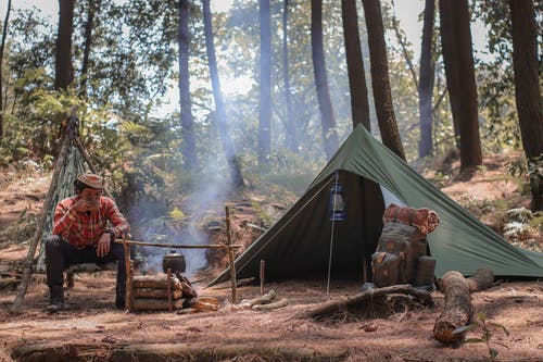 徒步旅行者在旅行期间在火和帐篷附近休息 · 免费素材图片
