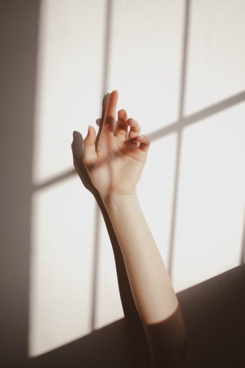 女手靠墙与阴影 · 免费素材图片