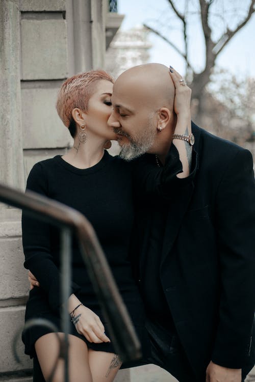 时尚的成年夫妇，在大街上接吻的黑色服装 · 免费素材图片