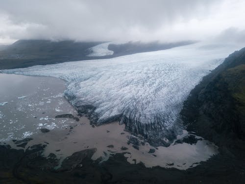 雄伟的冰川舌在阴沉的朦胧天空下到达海边 · 免费素材图片
