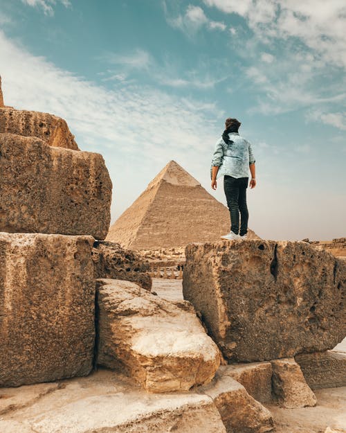 旅行者站在沙漠中的石碑上 · 免费素材图片