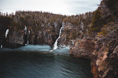 狭窄的瀑布，在雄伟的岩石峭壁 · 免费素材图片