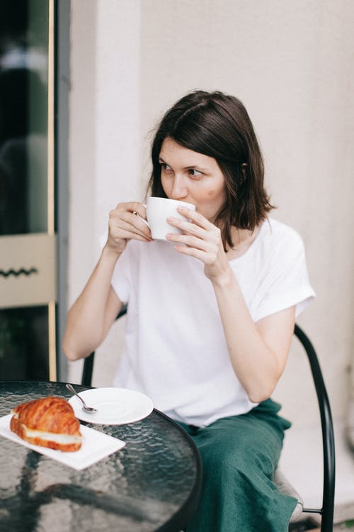 喝咖啡时坐着的女人的照片 · 免费素材图片