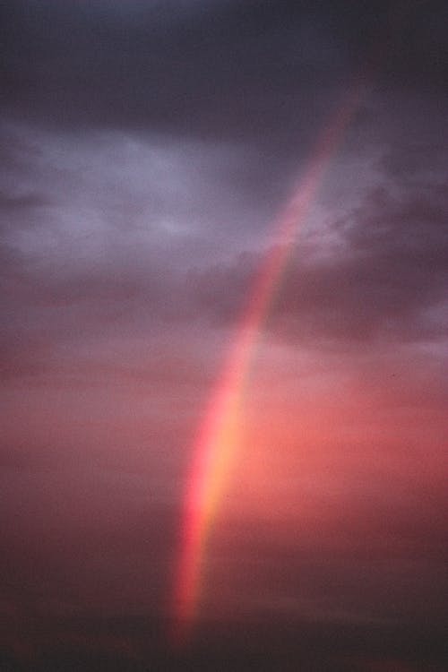 彩虹在多云的天空，在日落时 · 免费素材图片