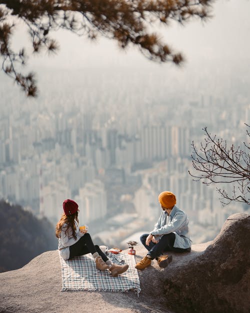 男人和女人坐在岩石上 · 免费素材图片
