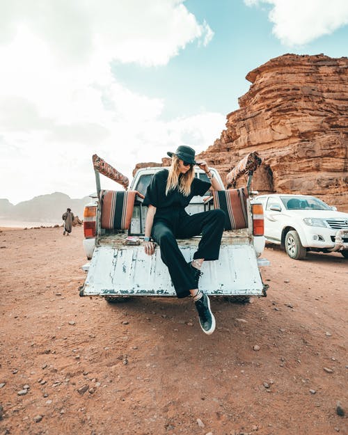 时尚的女人坐在沙漠地区的车上 · 免费素材图片