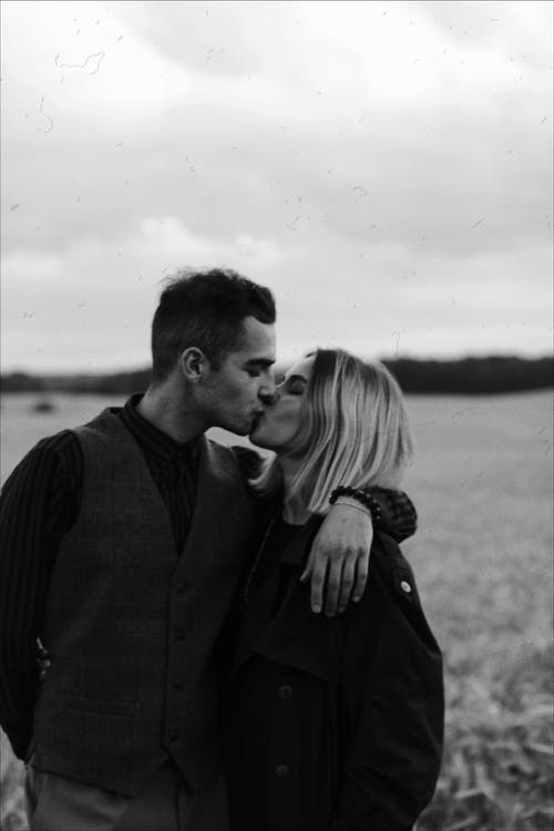 男人和女人接吻的灰度照片 · 免费素材图片