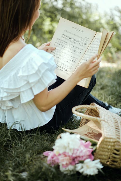 白顶读音乐书的女人 · 免费素材图片