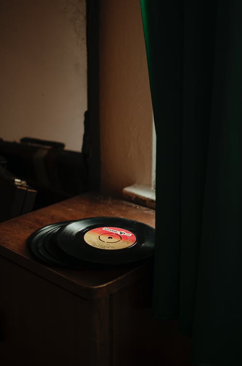 经典黑胶唱片放在木桌上 · 免费素材图片