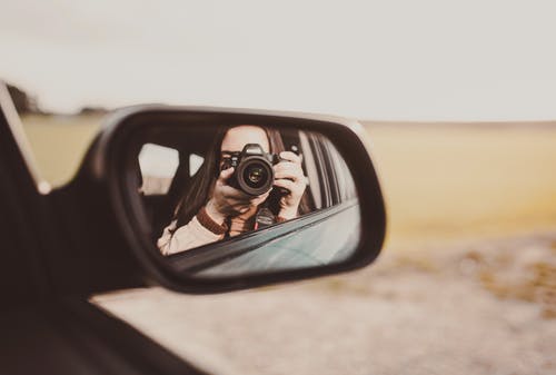 不可识别的女摄影师拍照并反映在后窗 · 免费素材图片