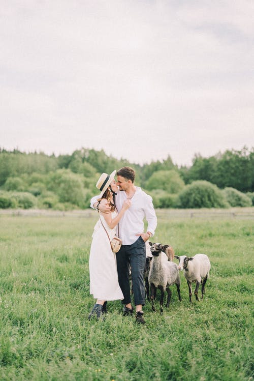 夫妻在与羊场上行走 · 免费素材图片