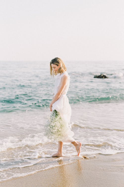 站在海滩上的白色连衣裙的女人 · 免费素材图片
