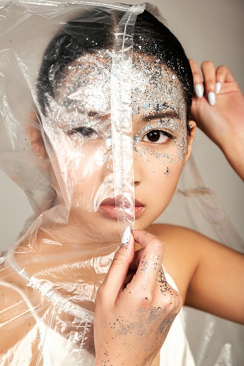 年轻的亚裔女子脸上覆盖着雨衣和金属丝 · 免费素材图片
