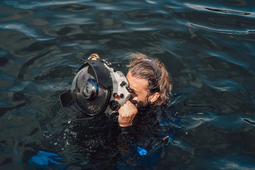 无法识别的潜水员在水盒中的设备上拍照 · 免费素材图片