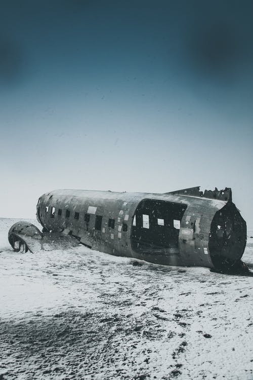 天空下白雪皑皑的土地上被毁的飞机机舱 · 免费素材图片