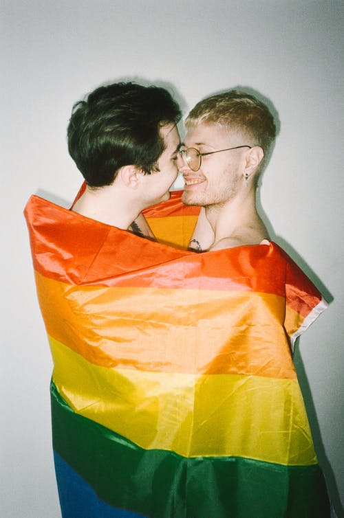 裹在同性恋骄傲旗帜中的男人 · 免费素材图片