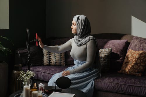 灰色头巾的女人坐在紫色的沙发上 · 免费素材图片