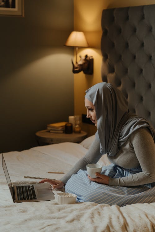 坐在床上的灰色头巾的女人 · 免费素材图片