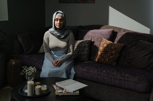 坐在长沙发上的灰色长袖衬衫的女人 · 免费素材图片