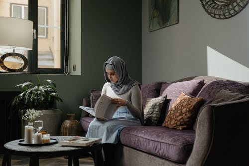 女人阅读本书坐在沙发上 · 免费素材图片