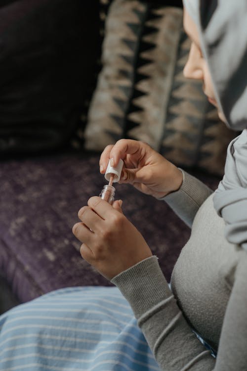 拿着银戒指的灰色长袖衬衫的人 · 免费素材图片