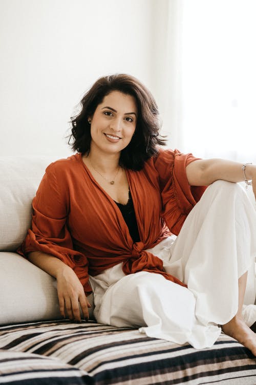 女人坐在沙发上的照片 · 免费素材图片