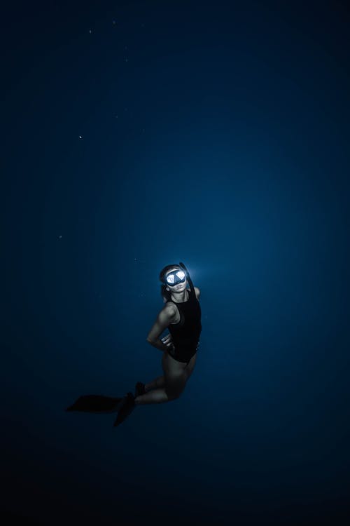 无法识别的女人，在蓝色的海水中潜水 · 免费素材图片