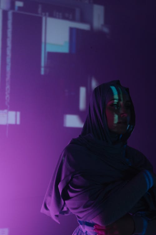 黑色头巾的女人站在紫色的墙附近 · 免费素材图片