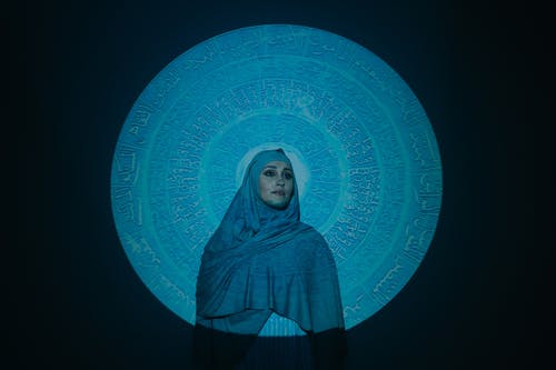 站在蓝色和白色的墙壁旁边的蓝色头巾的女人 · 免费素材图片