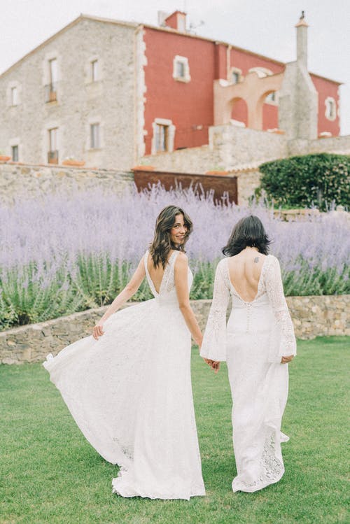 在白色的婚纱礼服在草地上行走的妇女的照片 · 免费素材图片