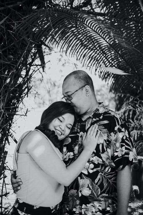 男人亲吻他的女人的灰度照片 · 免费素材图片