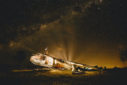 匿名夫妇在黄昏时拥抱在废弃的飞机上 · 免费素材图片